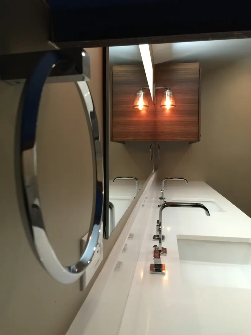 Modern bathroom sink with round mirror and minimalist design.
