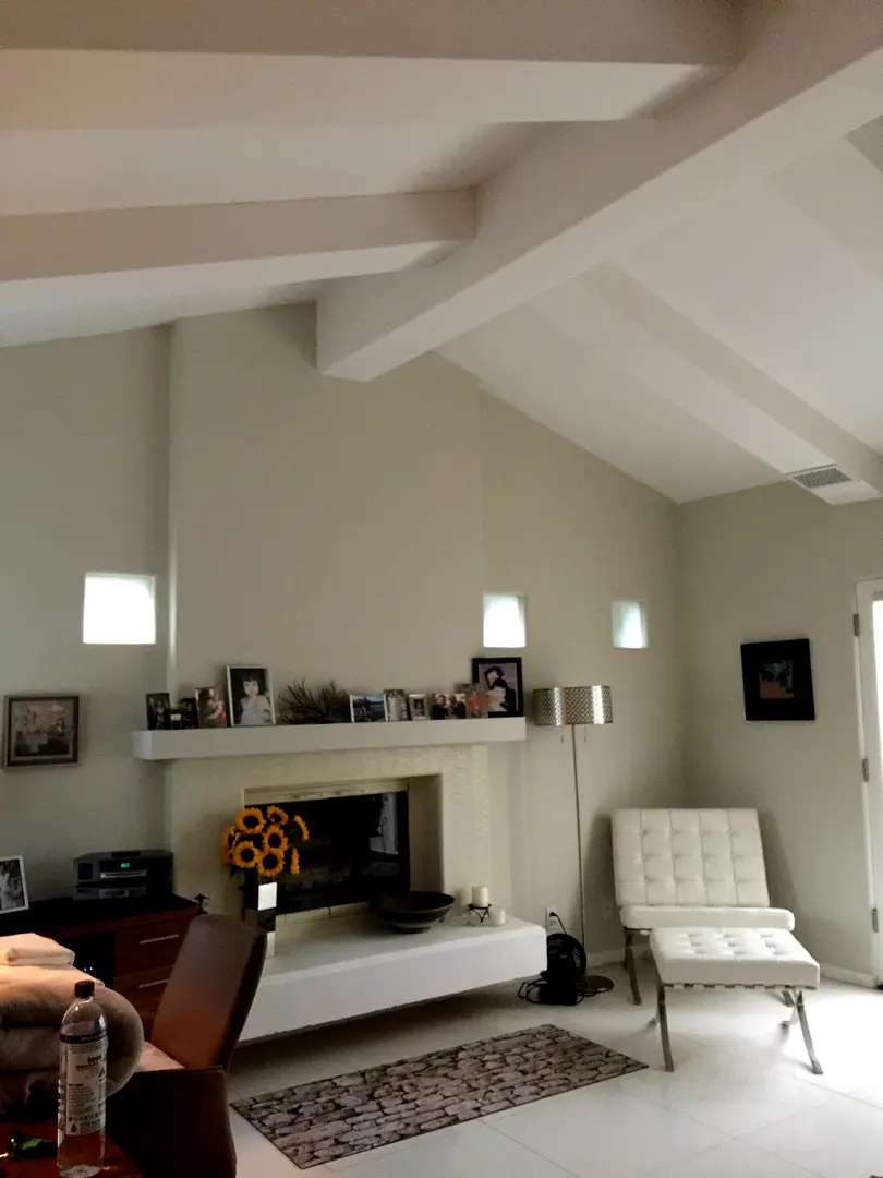 Cozy living room with vaulted ceiling, white furniture, and warm lighting.
