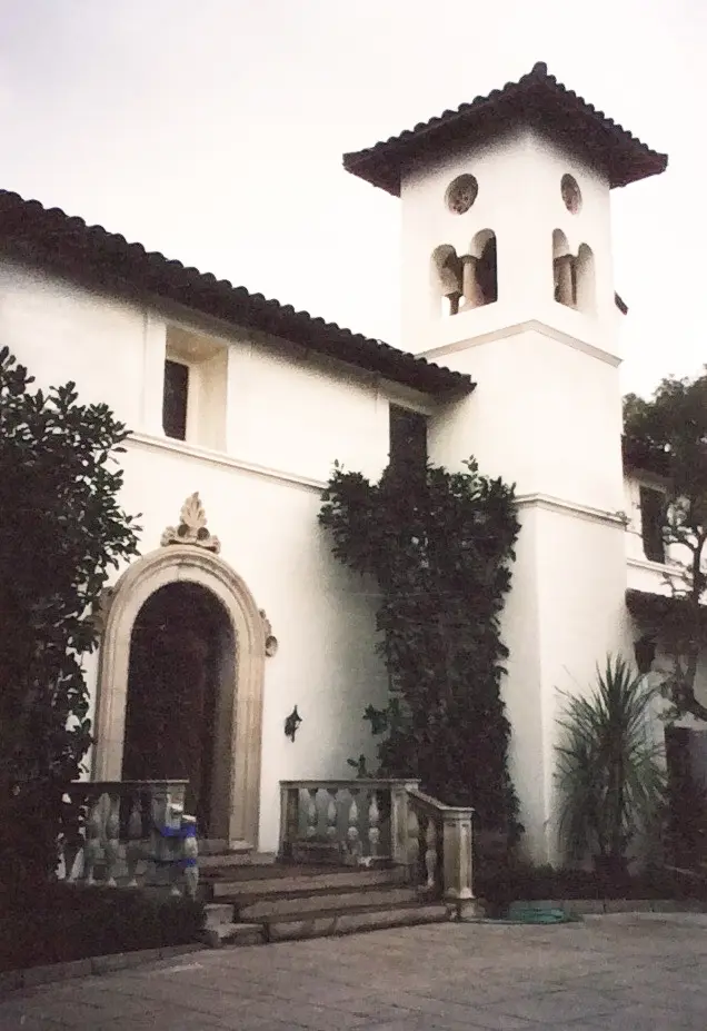 White building with a bell tower and arched entrance.