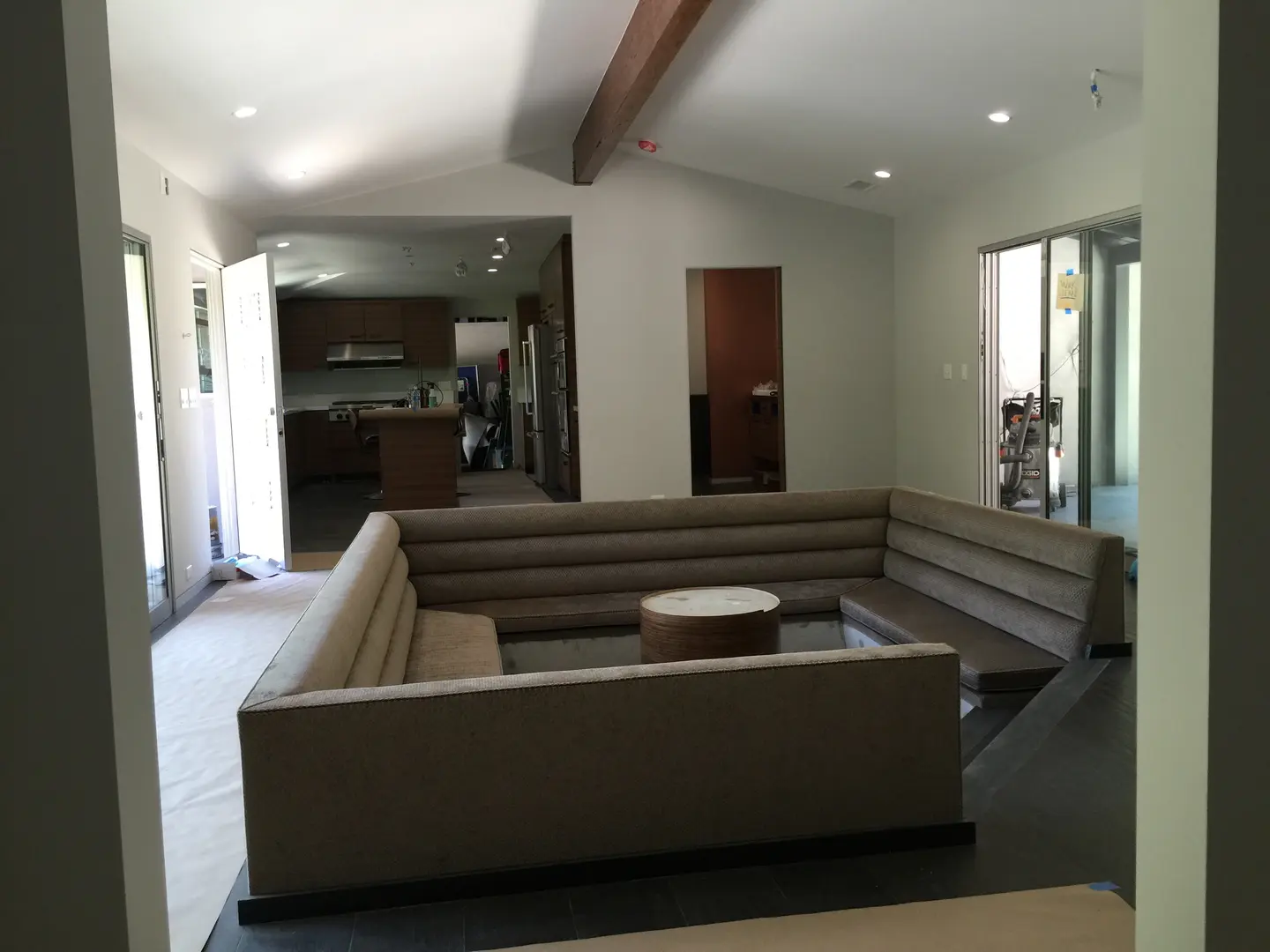 Modern living room with a large sectional sofa and open kitchen.