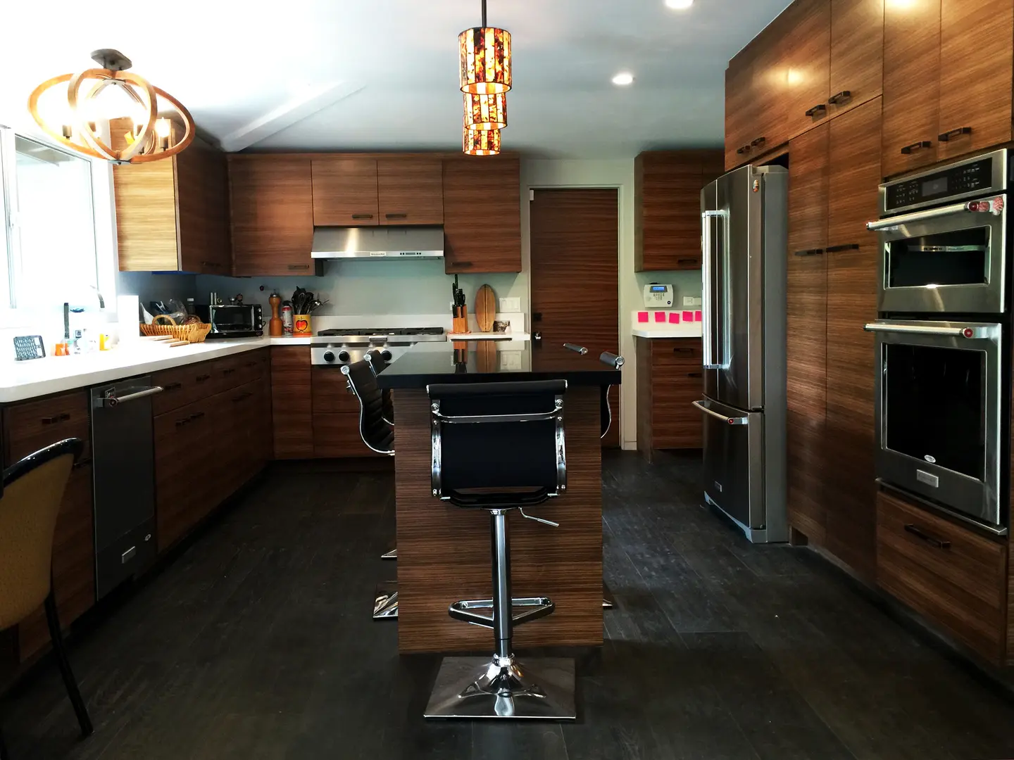 Modern kitchen with dark wood cabinets and a central island with a black bar stool.